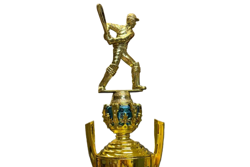 Gold trophy with a baseball player figure on top, placed on a chair.