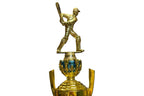 Gold trophy with a baseball player figure on top, placed on a chair.