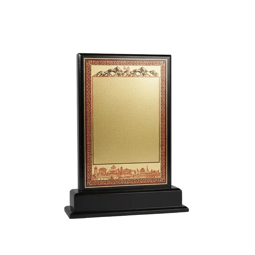 Decorative plaque with gold center and black frame on a desk